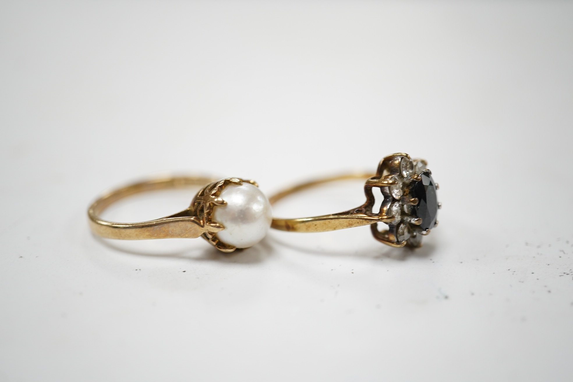 A 9ct gold, sapphire and simulated diamond cluster set ring, size M and a 9ct gold and cultured pearl set ring, gross weight 5 grams. Condition - fair